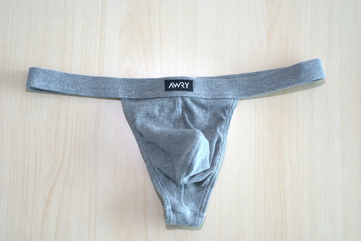 Front flat lay of the heather gray AWRY RIBBED Thong on a light wood surface.